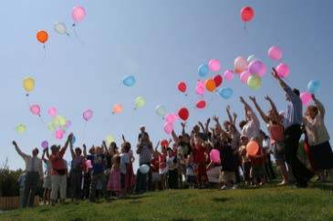 Group of people releasing balloons into the air